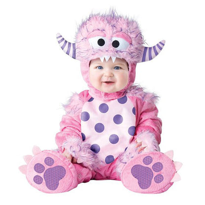 Baby in a pink and purple monster costume on a white background